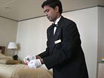 A butler serving vacationers aboard the cruise ship Queen Victoria.